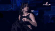a woman in a black dress is on a colors hd channel