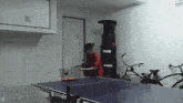 a man is playing ping pong on a table that says ping pong