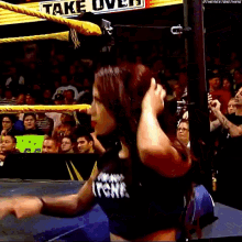 a woman is in a wrestling ring with a sign that says fake live on it