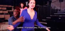 a woman in a blue top is talking to another woman in a stadium .