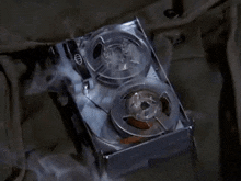 a tape recorder with smoke coming out of it is sitting on a table