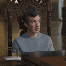 a man is sitting in a chair with uhh sure written on the table