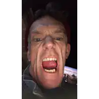 a man wearing a red hat is making a funny face with his tongue out