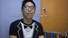 a man wearing glasses and a tuxedo says aaay