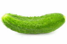 a green cucumber on a white background with a few spots on it