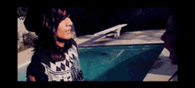 a man and a woman are kissing by a pool .