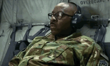 a man in a military uniform is wearing headphones and glasses