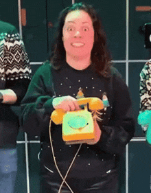 a woman is talking on a yellow telephone and making a face
