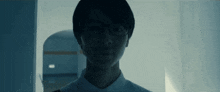 a close up of a person wearing glasses in a dark room .