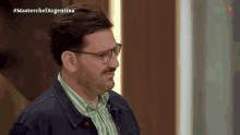 a man wearing glasses and a striped shirt is on a tv show called master chef argentina