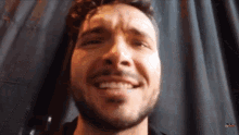 a close up of a man 's face with a beard smiling .
