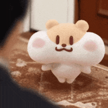 a stuffed animal with a face on it is standing on a rug .
