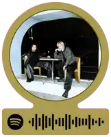 a picture of two men sitting at a table with a spotify code below it