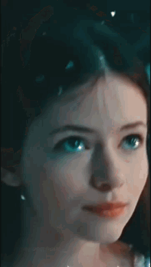 a close up of a young girl 's face with blue eyes