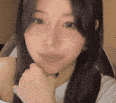a close up of a woman with her hand on her chin