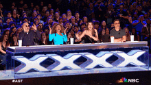 a group of people sitting in front of a sign that says xxx on it