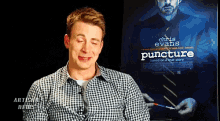 a man in front of a movie poster for puncture