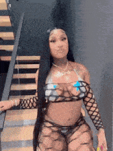 a woman is standing on a set of stairs wearing a bikini and stockings .