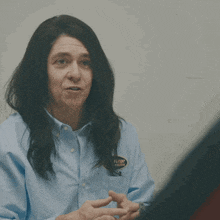 a man with long hair is pointing at something with the words that 's godmode written above him