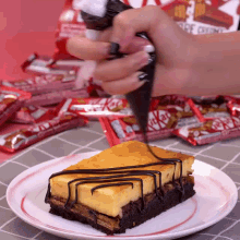 a white plate with a piece of cake on it and a bag of kitkats in the background