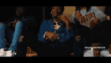 a man in a striped sweater is standing in a room with worldstarhiphop.com written on the bottom of the screen