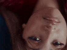 a close up of a woman 's face upside down with her eyes closed .