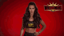 a woman is standing in front of a wrestlemania sign