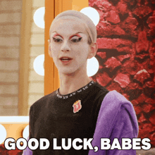 a person with a wig on their head says good luck babes