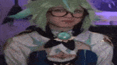 a woman with green hair and glasses is wearing a costume and looking at the camera .