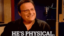 a man is laughing in front of a microphone and saying `` he 's physical . ''