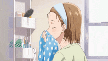 a girl wipes her face with a polka dot towel