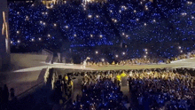 a crowd of people are watching a concert with a lot of lights on the stage