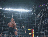 a wrestler wearing a shirt that says ' tnt ' on it is standing in a wrestling ring