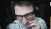 a man wearing glasses and headphones is looking at the camera