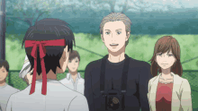a man with a camera around his neck talks to another man and a woman