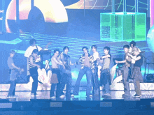 a group of people are dancing on a stage with a sign in the background that says " se "