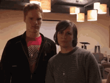 a man and a woman are standing next to each other in a dark room