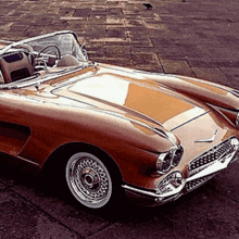 a brown sports car with a convertible top is parked on the side of the road