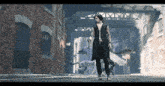 a man in a black vest is walking down a street with a dog behind him .