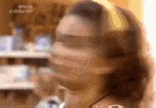 a blurry image of a woman 's face with a sign in the background that says ' oinos '