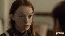 a girl with red hair and freckles is looking at a man with netflix written on the bottom