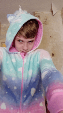 a boy wearing a unicorn hoodie takes a picture