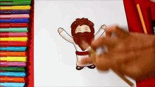 a drawing of jesus with his arms outstretched is being drawn on a piece of paper