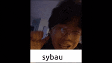 a close up of a person 's face with the word sybau on the bottom right