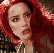 a woman with red hair has a bloody face