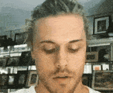 a close up of a man 's face with his eyes closed in front of a wall filled with pictures .