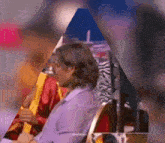 a man in a purple shirt is sitting in a chair with a zebra print chair in the background .
