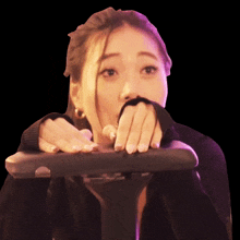 a woman covering her mouth with her hand while riding a bike