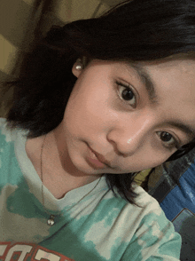 a girl wearing a tie dye shirt with the letter t on the front