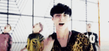 a man in a leopard print shirt is standing in front of a group of people .